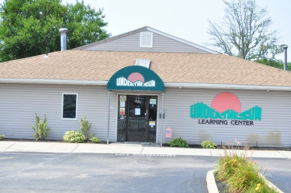 Building with a green awning over the entrance and a logo on the wall