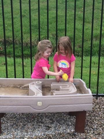 Two children playing with a water table