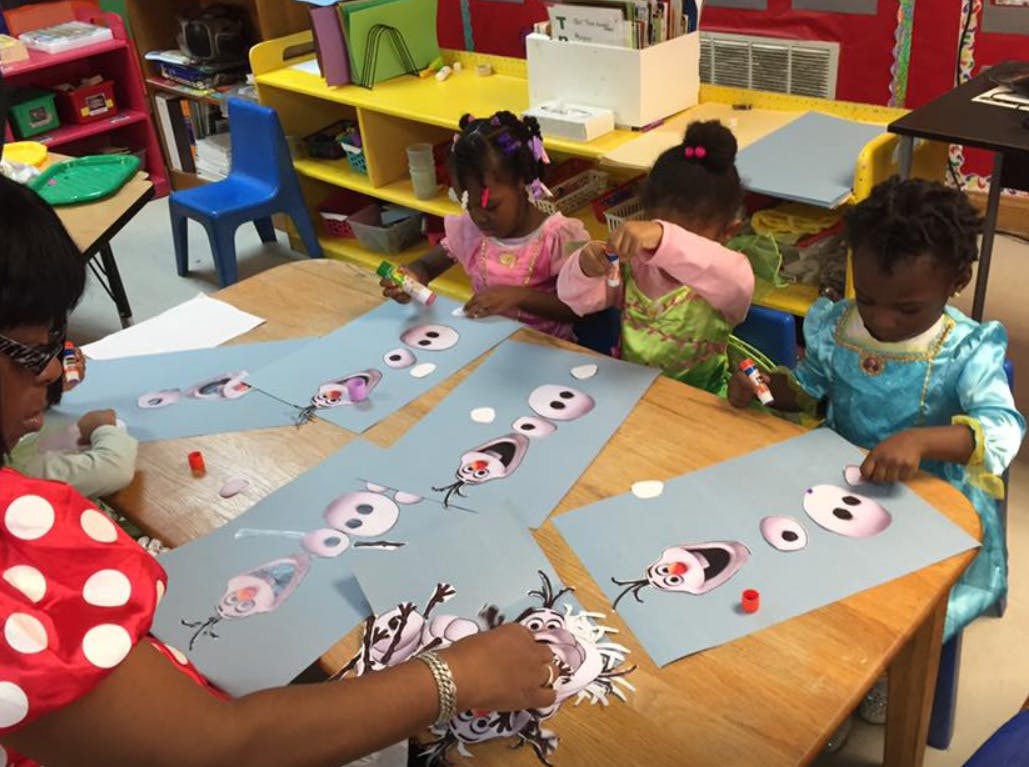 Adult and three children doing crafts at a table