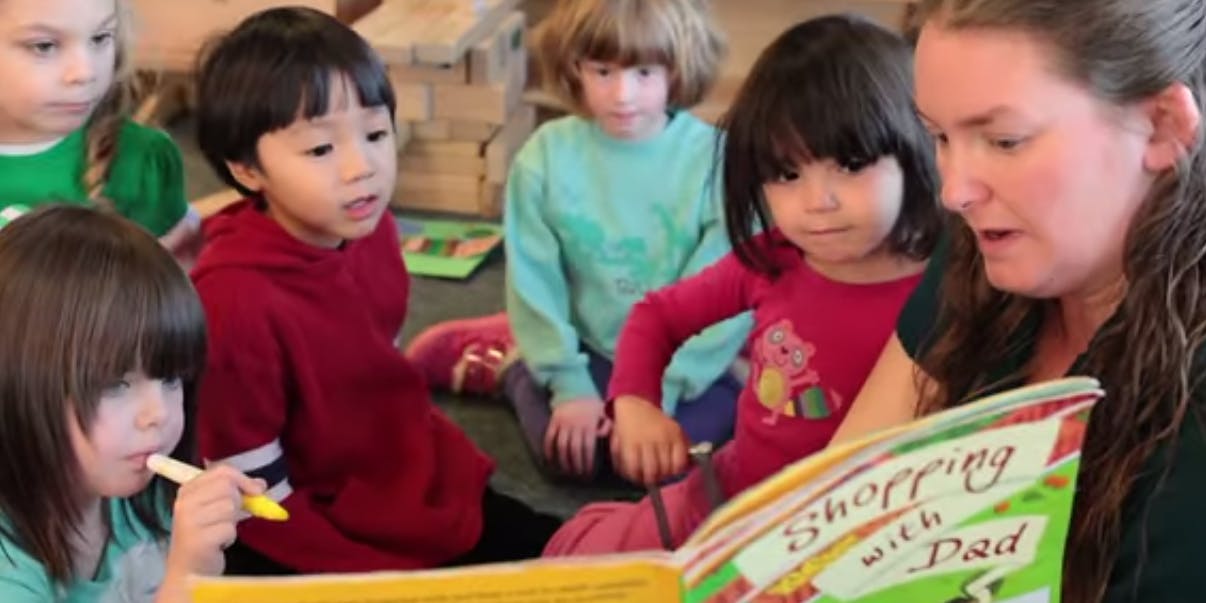 Adult reading a book to children