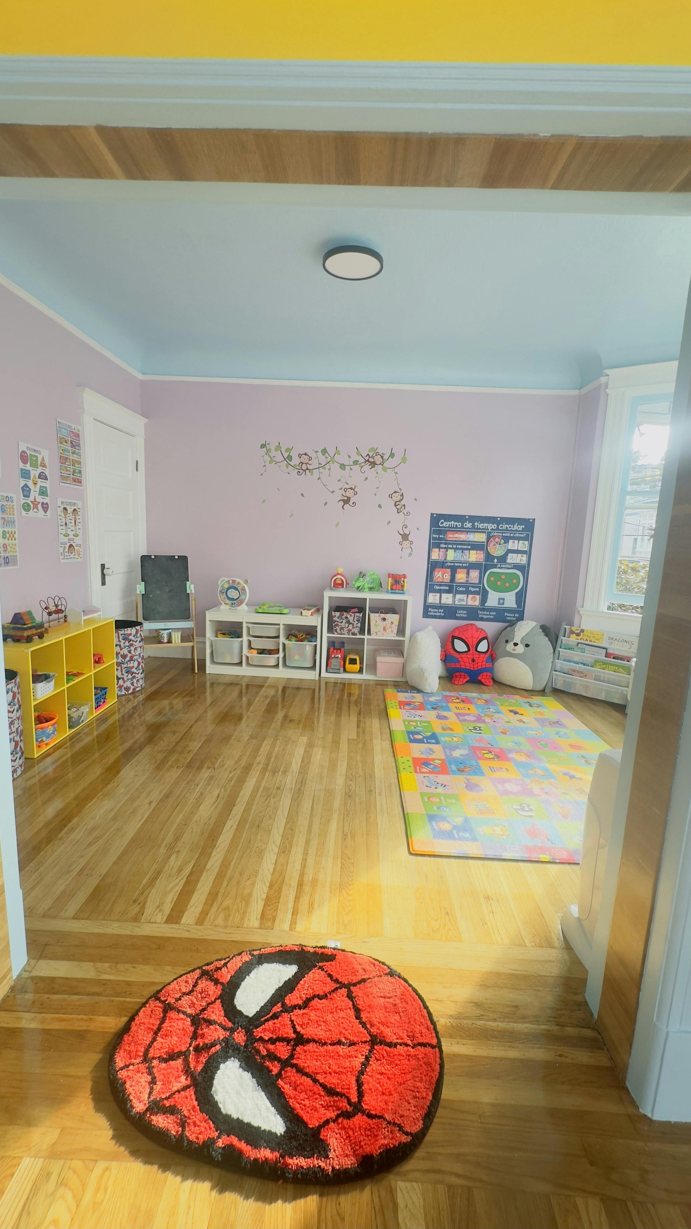 A children's playroom with colorful mats, toy storage, and wall decorations