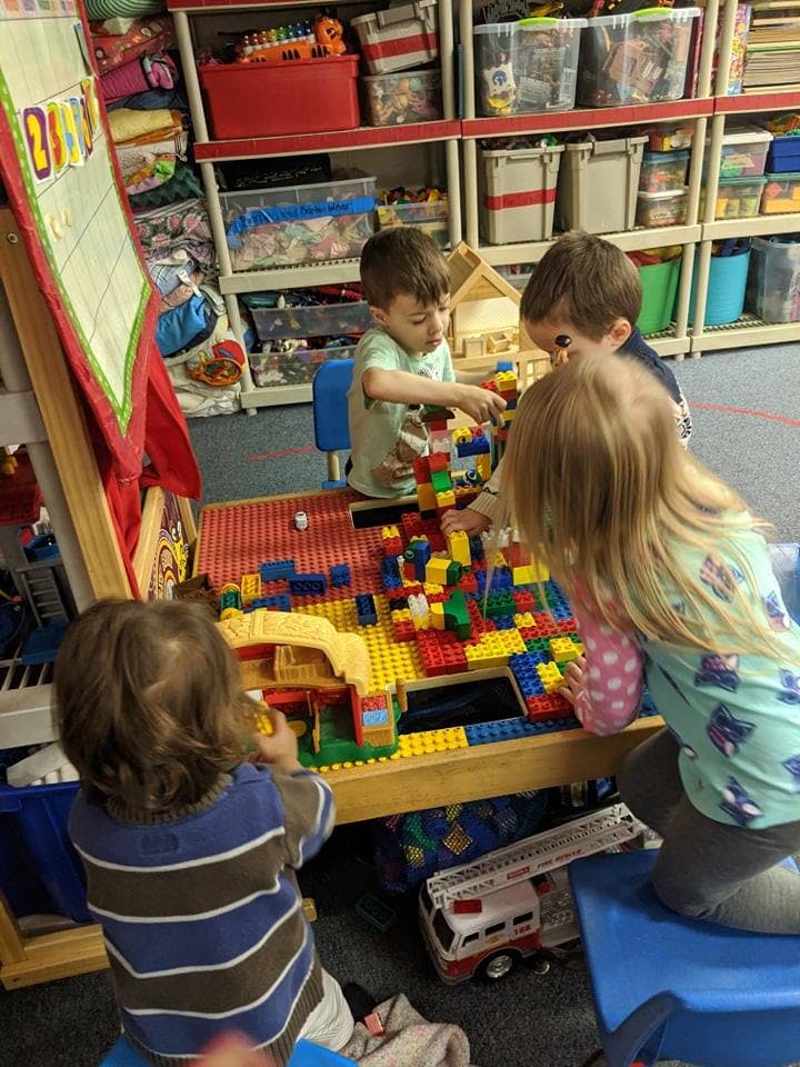 Children playing with colorful building blocks at a table