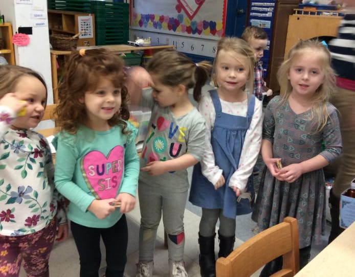 Five children standing in a classroom