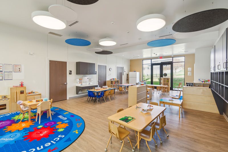A colorful classroom with small tables and chairs for children