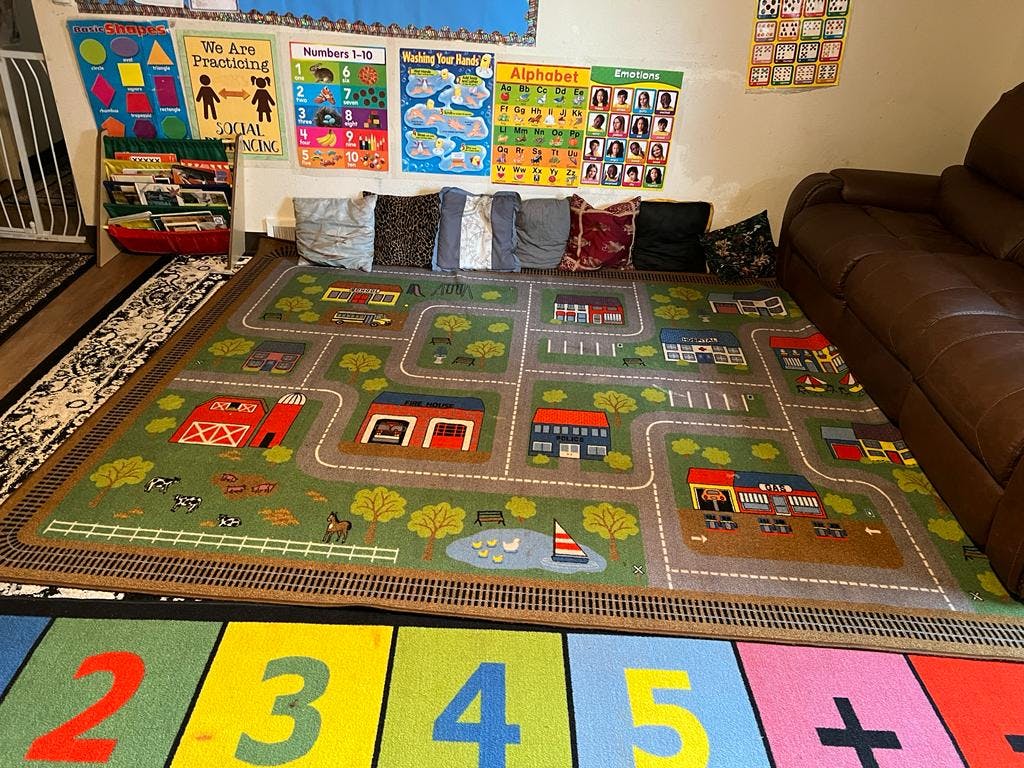 Playroom with a road map rug and educational posters on the wall