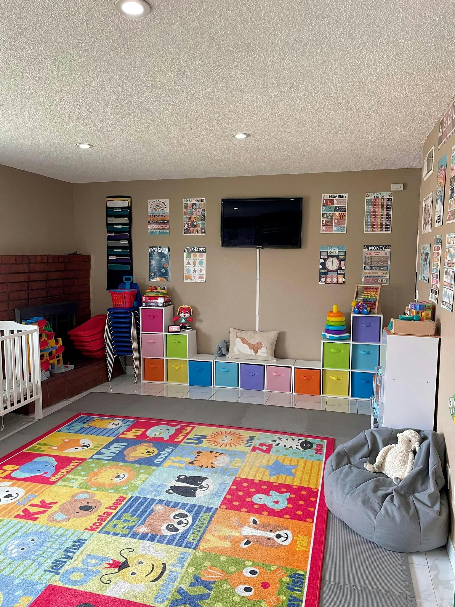 Playroom with colorful rug, crib, and storage cubbies