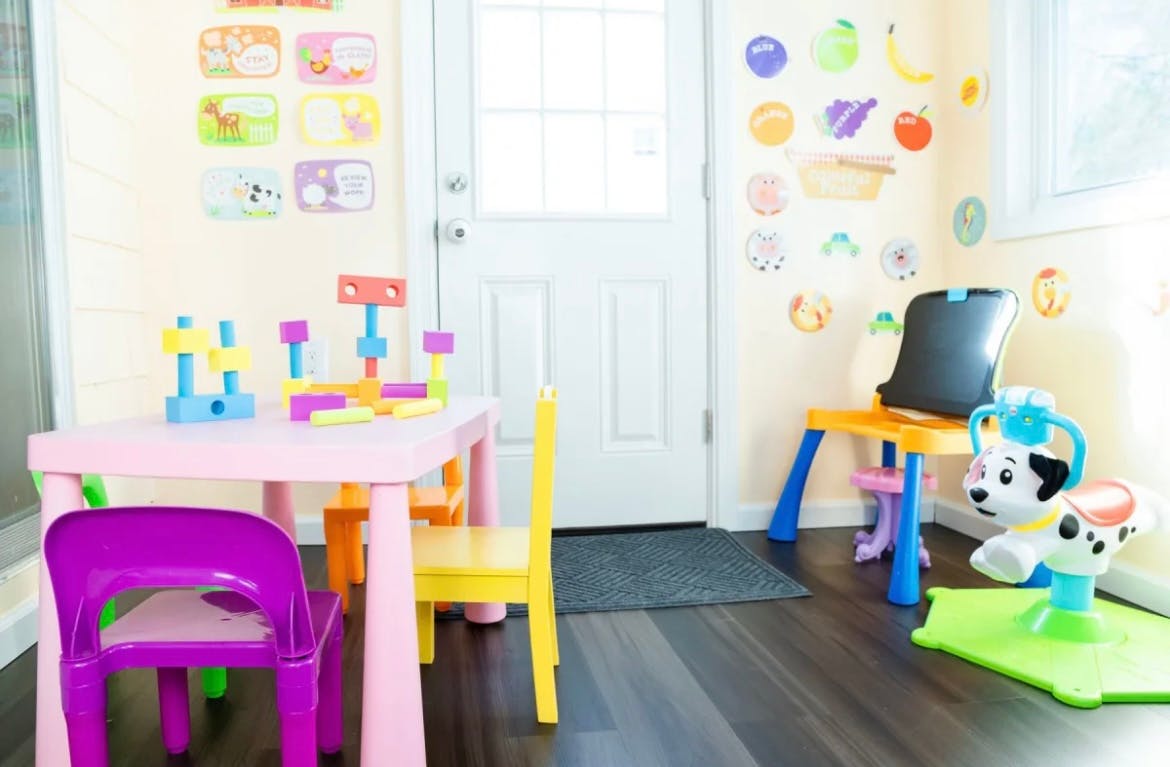 Playroom with a pink table, chairs, and building blocks