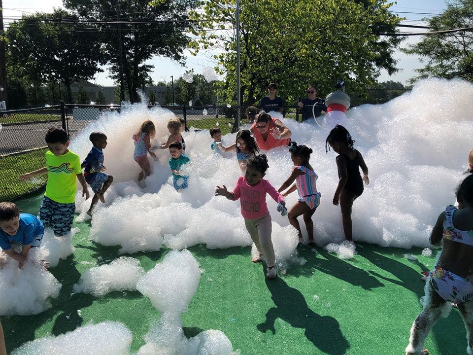 Children playing in a large pile of foam outdoors