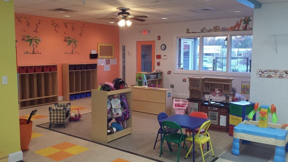 Empty classroom with small tables and cubbies