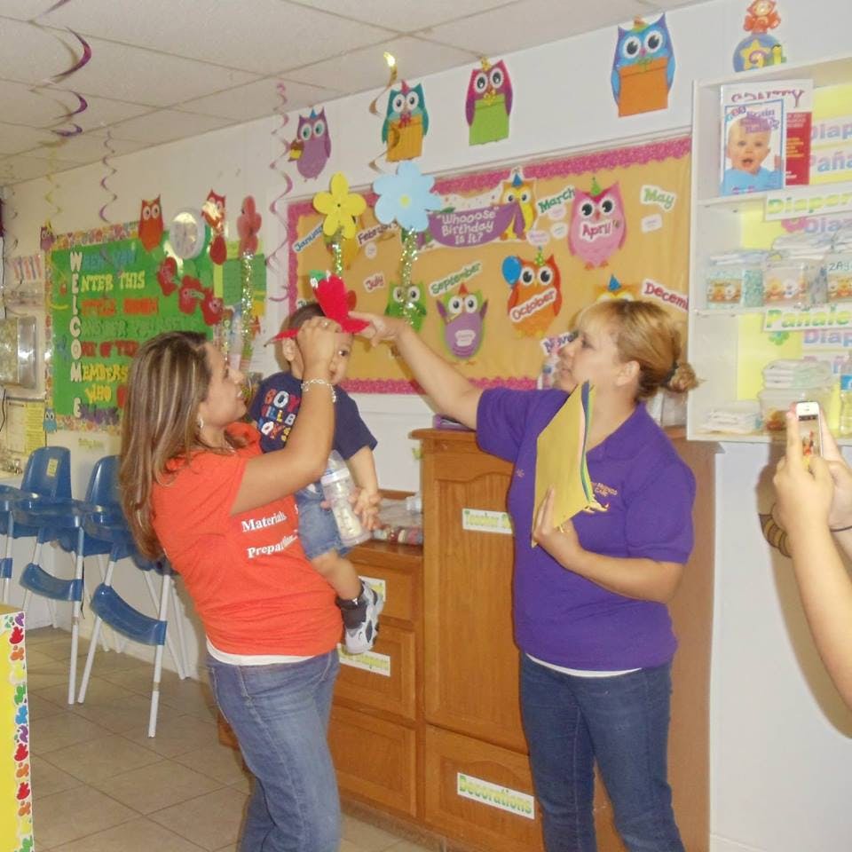 Two people interacting with a child in a classroom