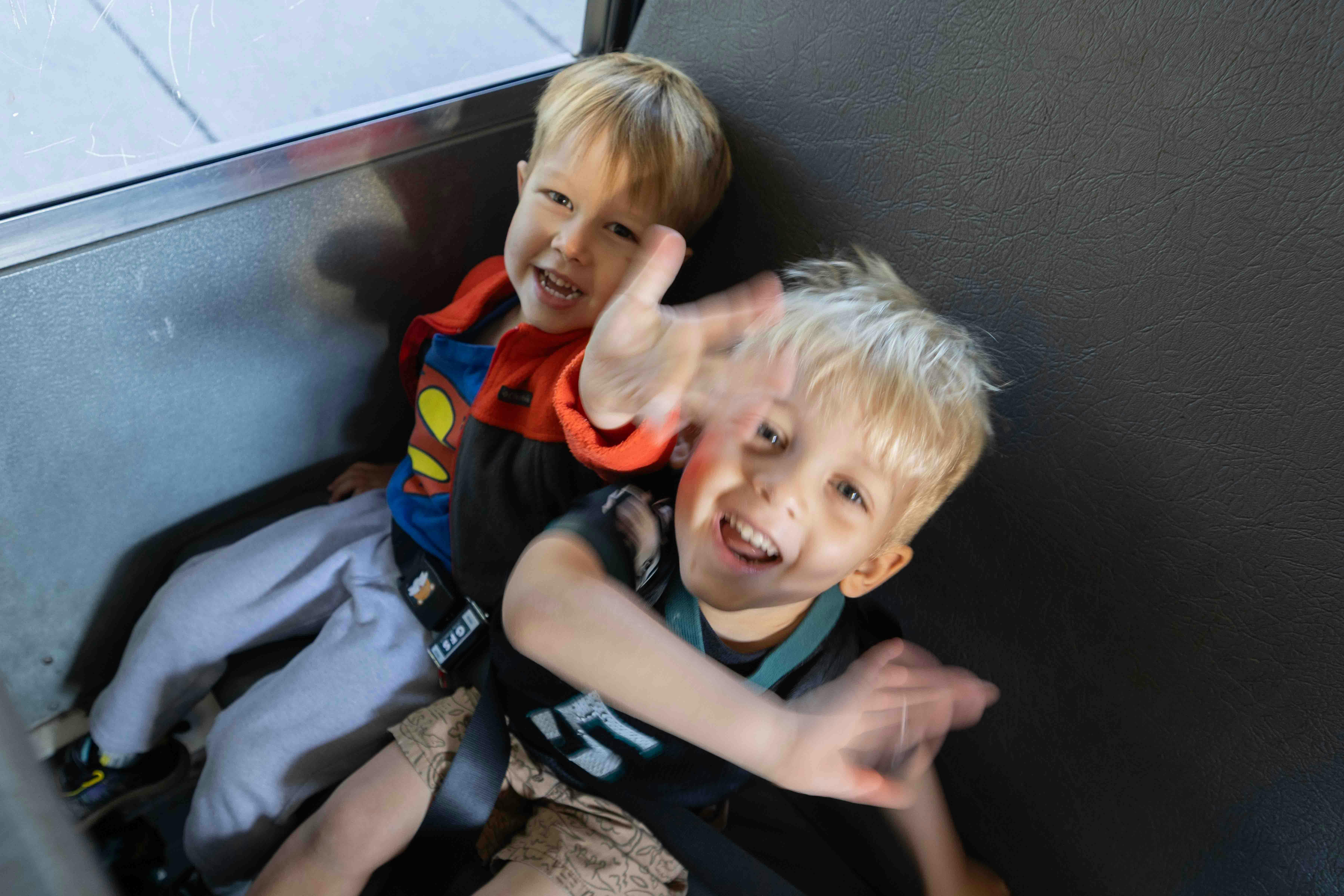 Two children seated side-by-side in a vehicle