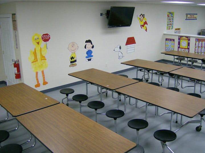 Empty cafeteria with tables and stools, wall decorations