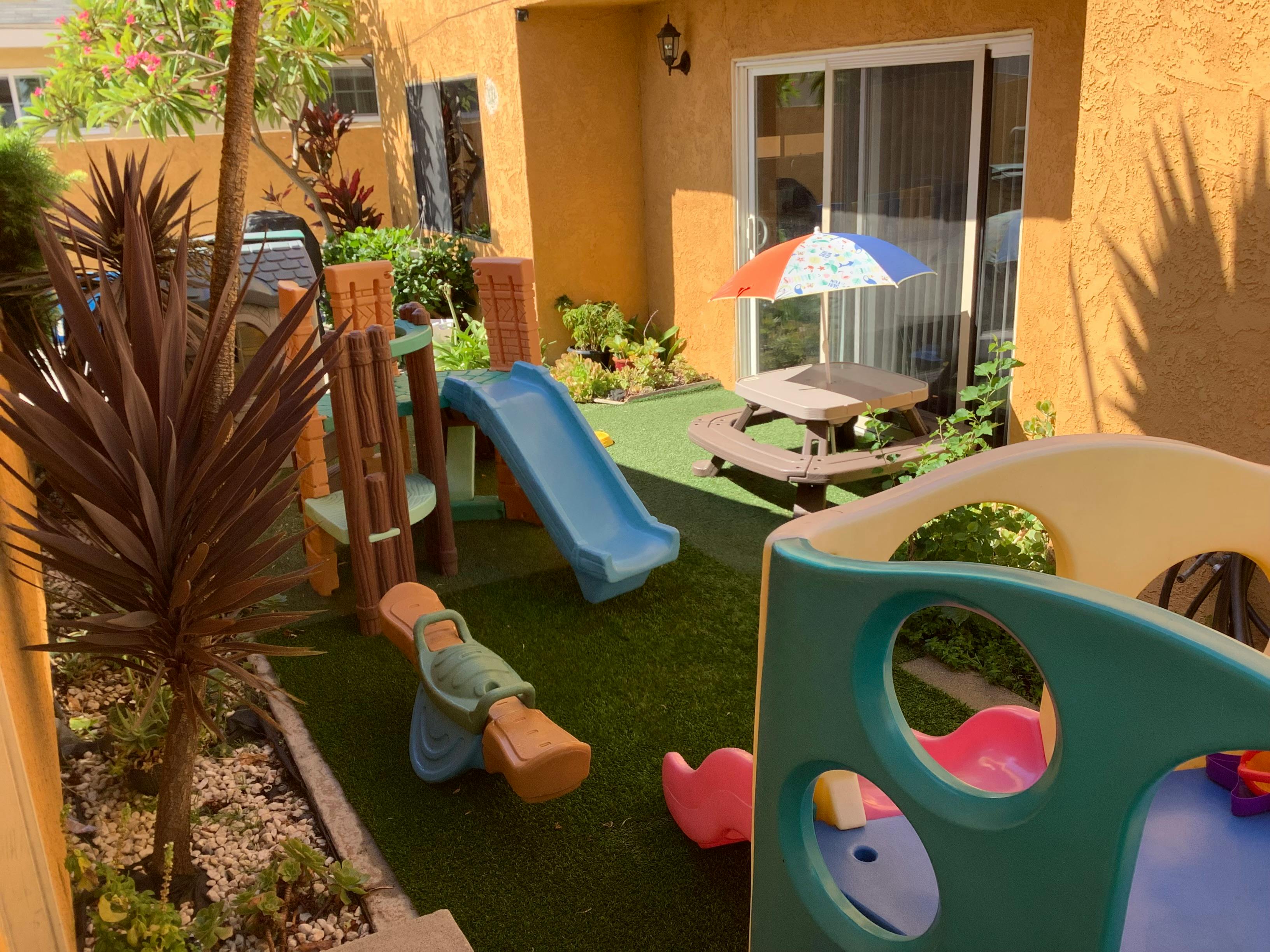 Outdoor play area with slides, seesaw, and picnic table