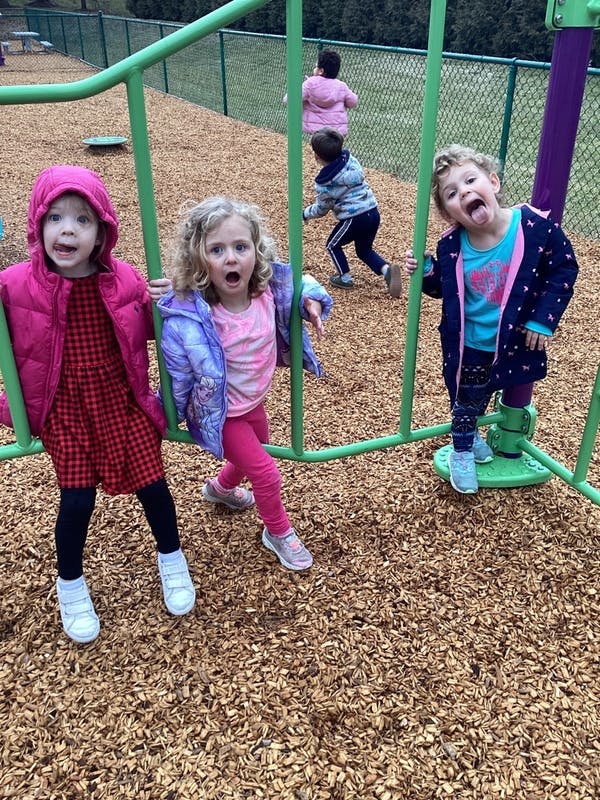 Three children playing on playground equipment