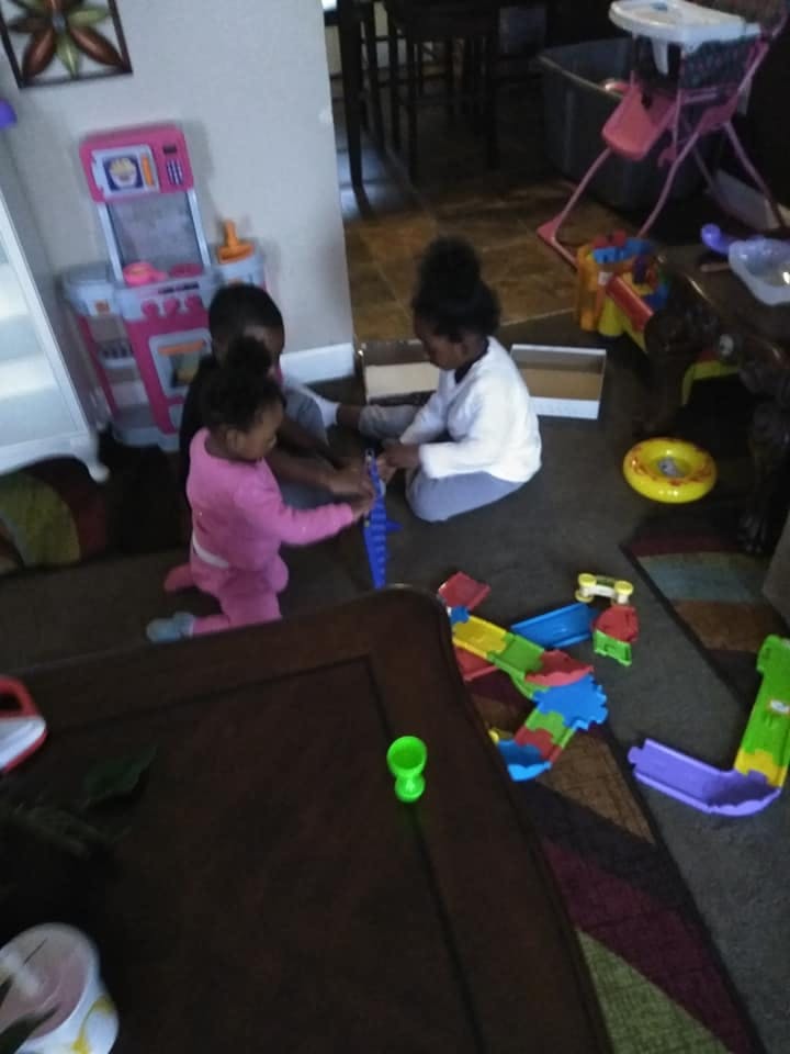 Three children playing with toys on the floor