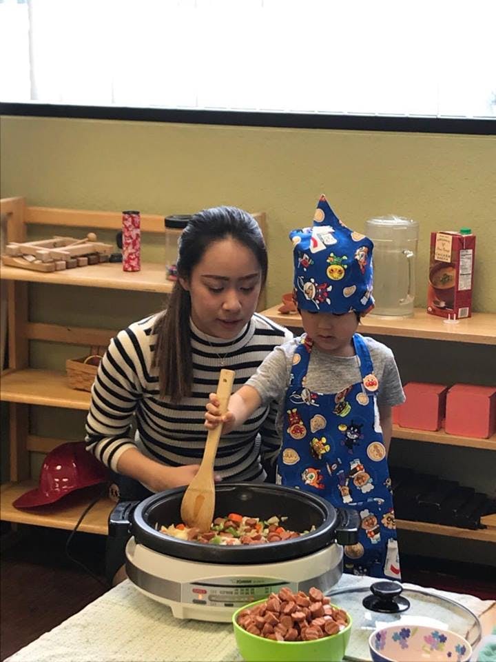 Person and child stirring food in a pot
