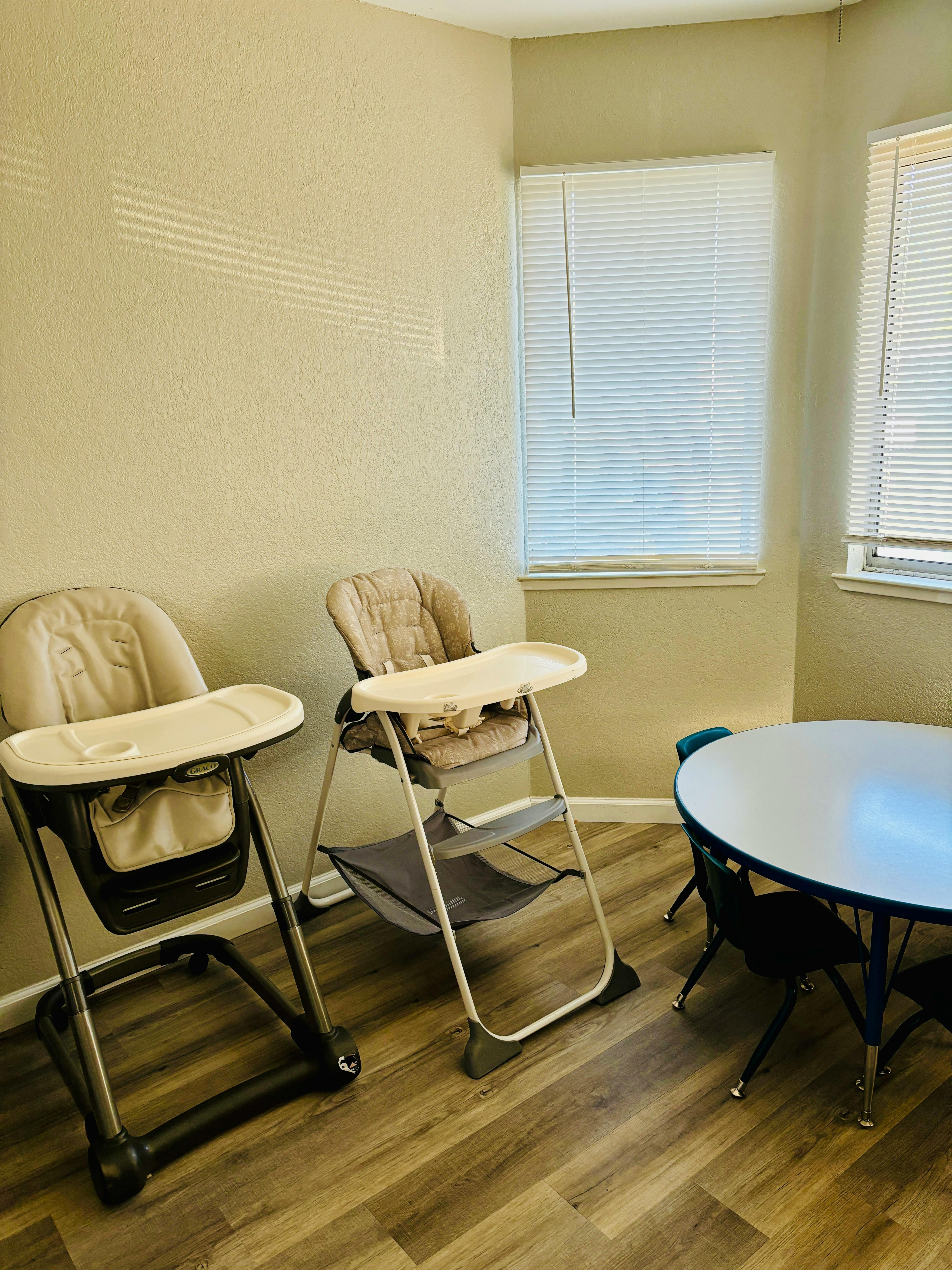 Two high chairs and a small round table with chairs in a room