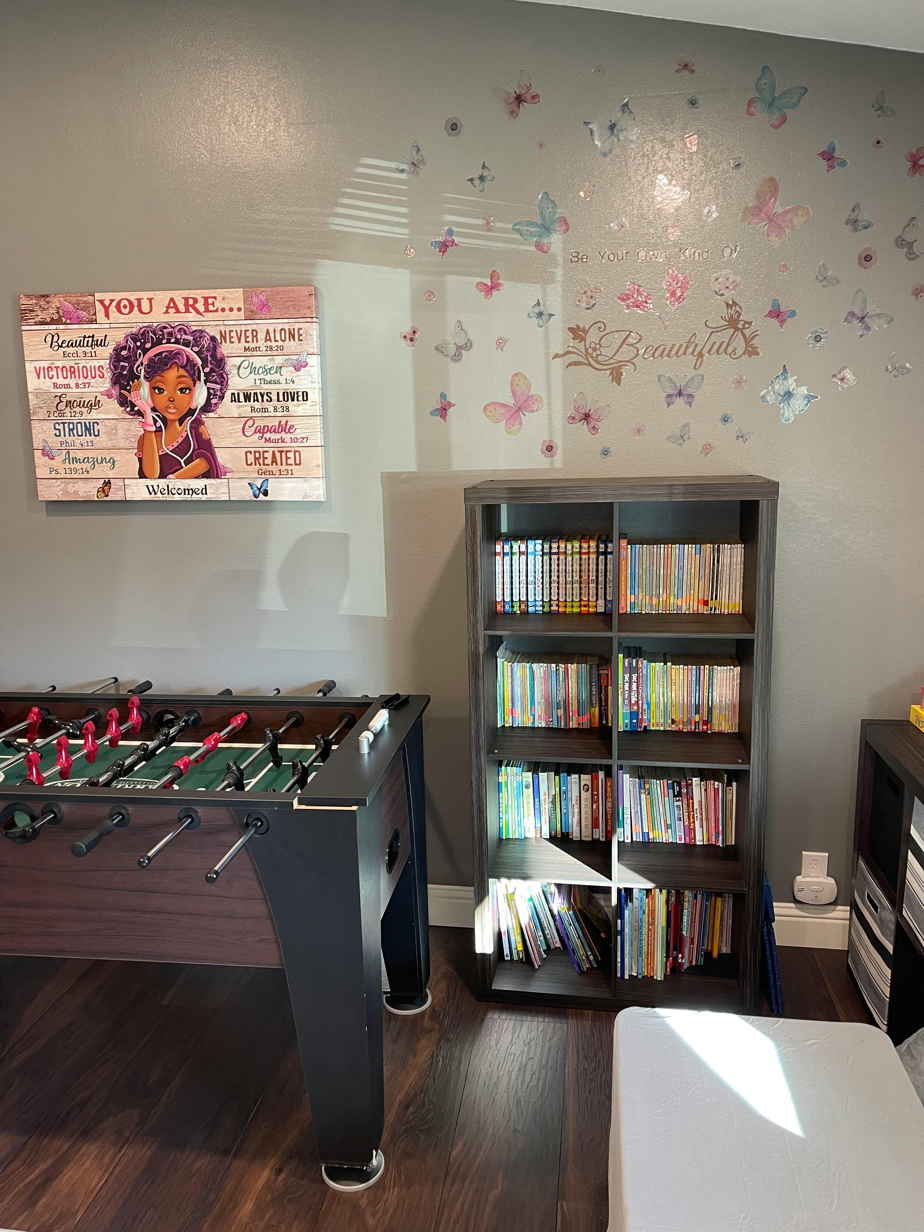 Foosball table next to a bookshelf filled with books
