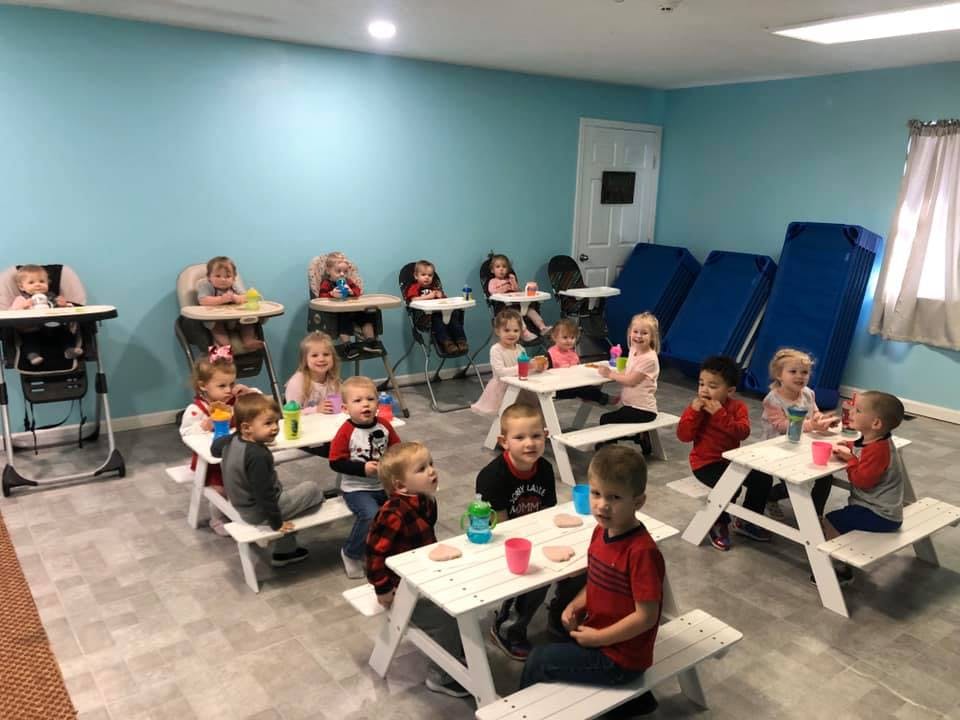 Many children sitting at tables in a classroom
