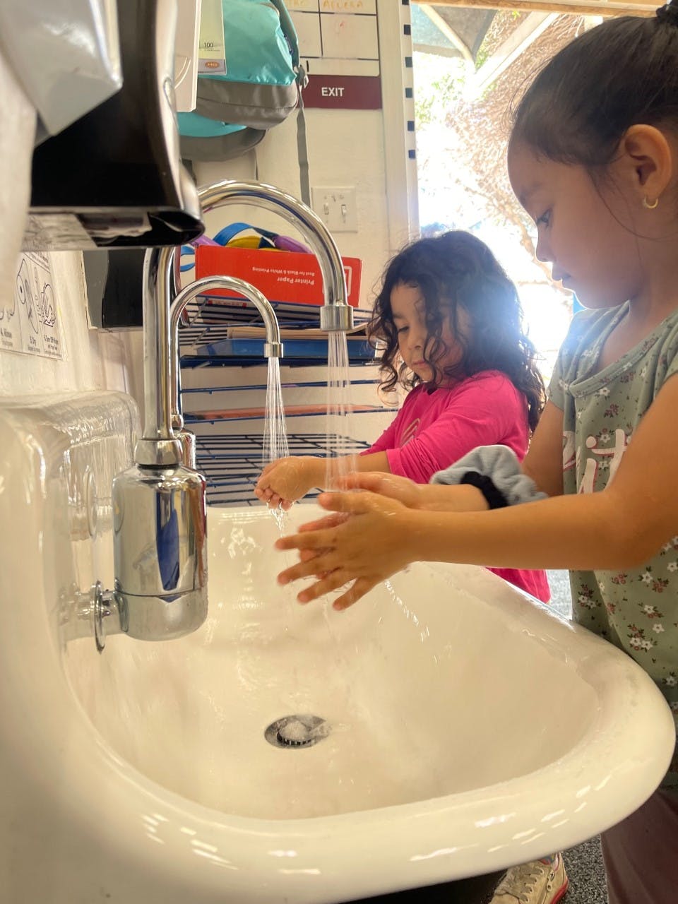 Two children washing hands at a sink