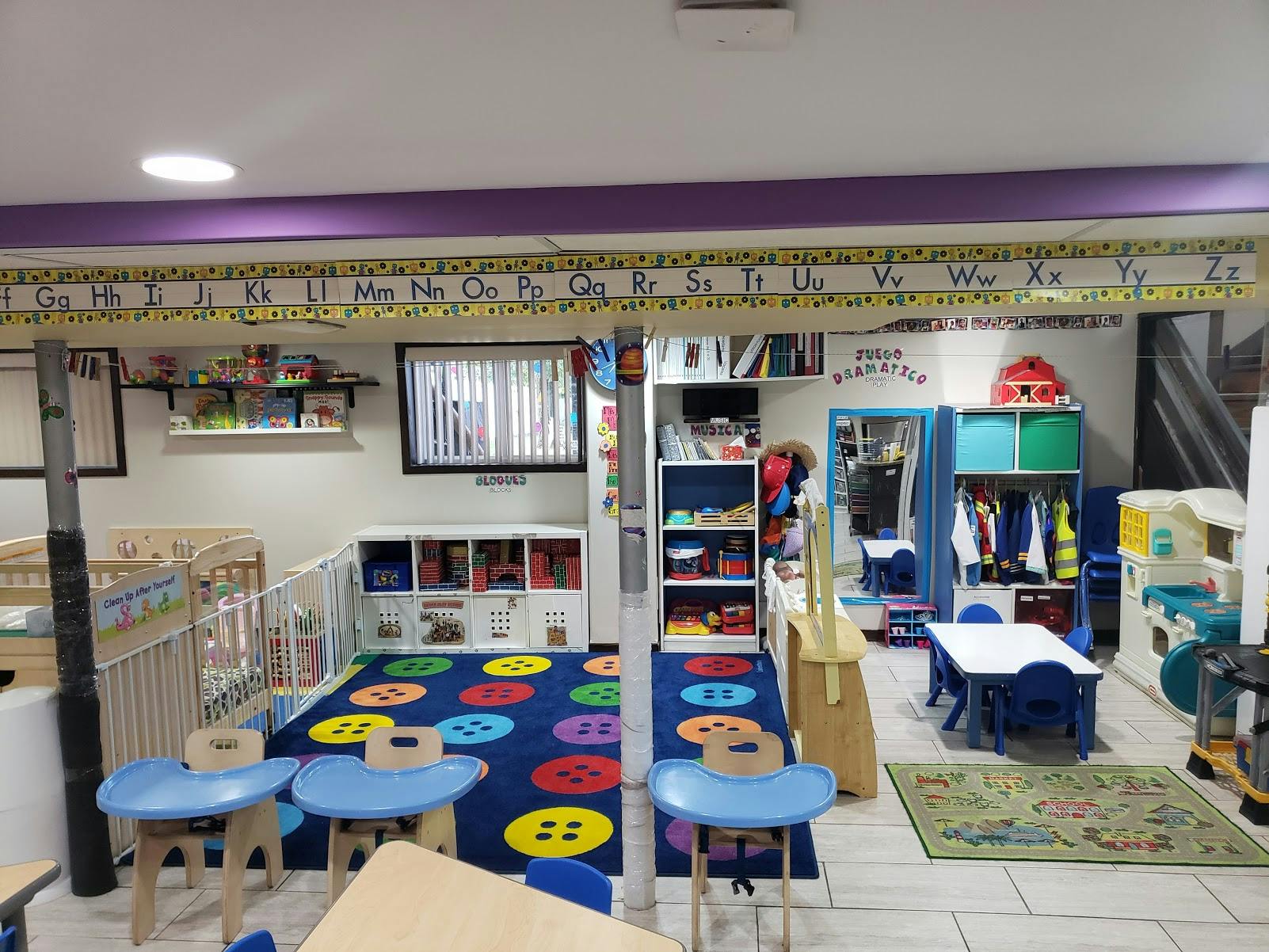 Childcare room with cribs, play mats, and small tables