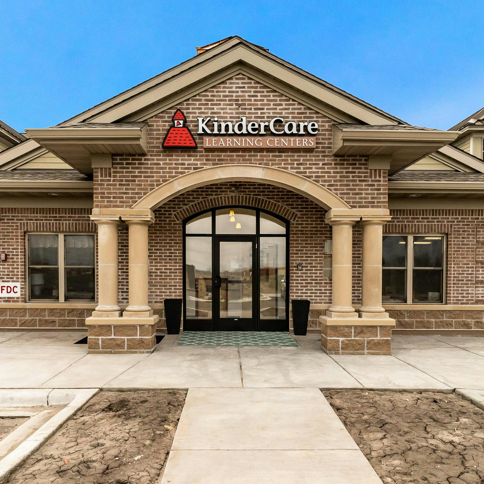 KinderCare Learning Centers sign on a brick building with an arched entrance