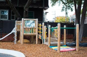 Empty playground with wooden structure, slide, and climbing bars