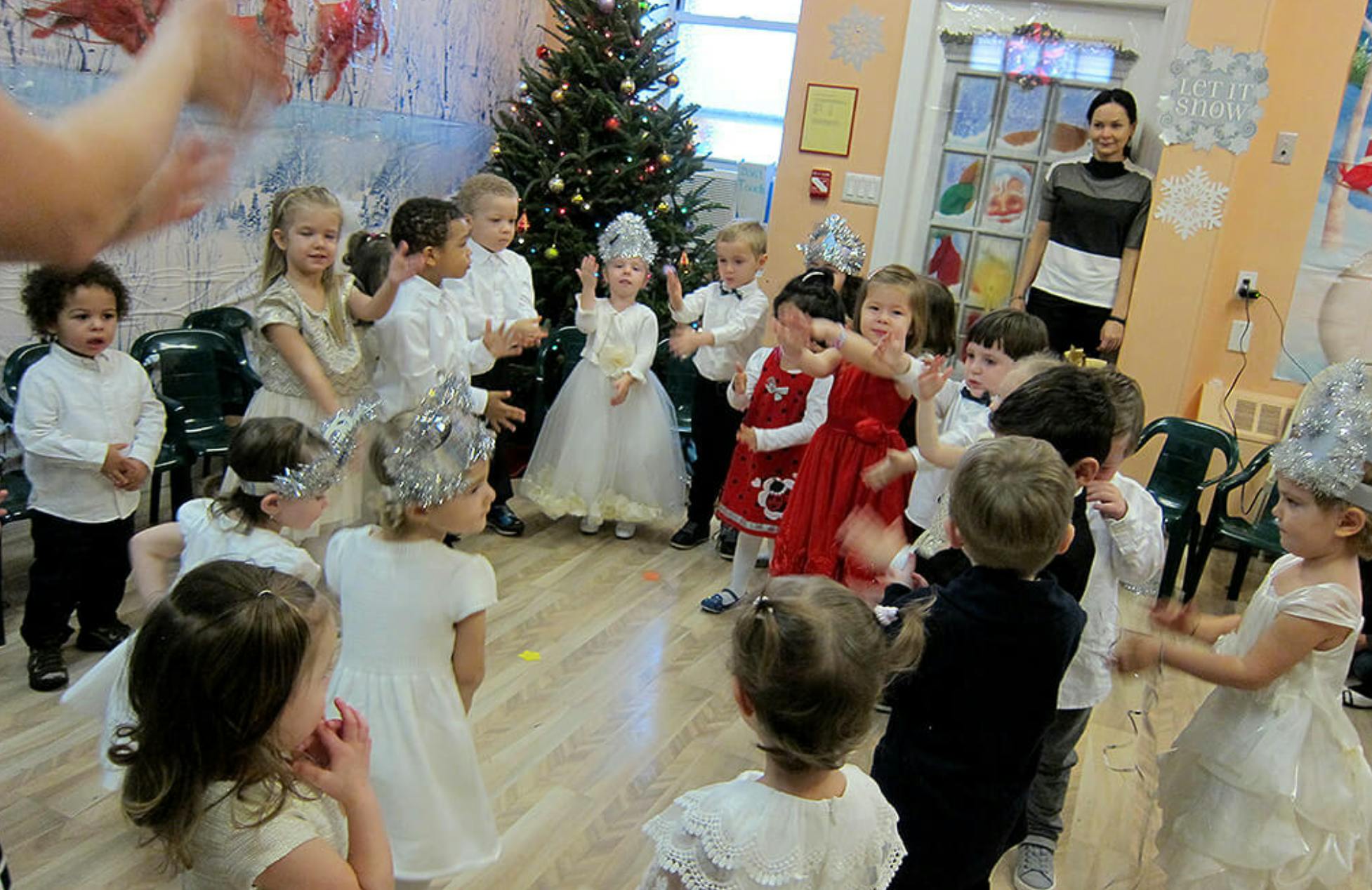 Children in a circle in a room with a Christmas tree