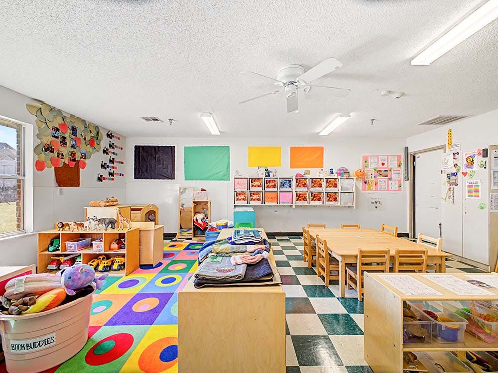 Colorful playroom or classroom with tables, chairs, and toys