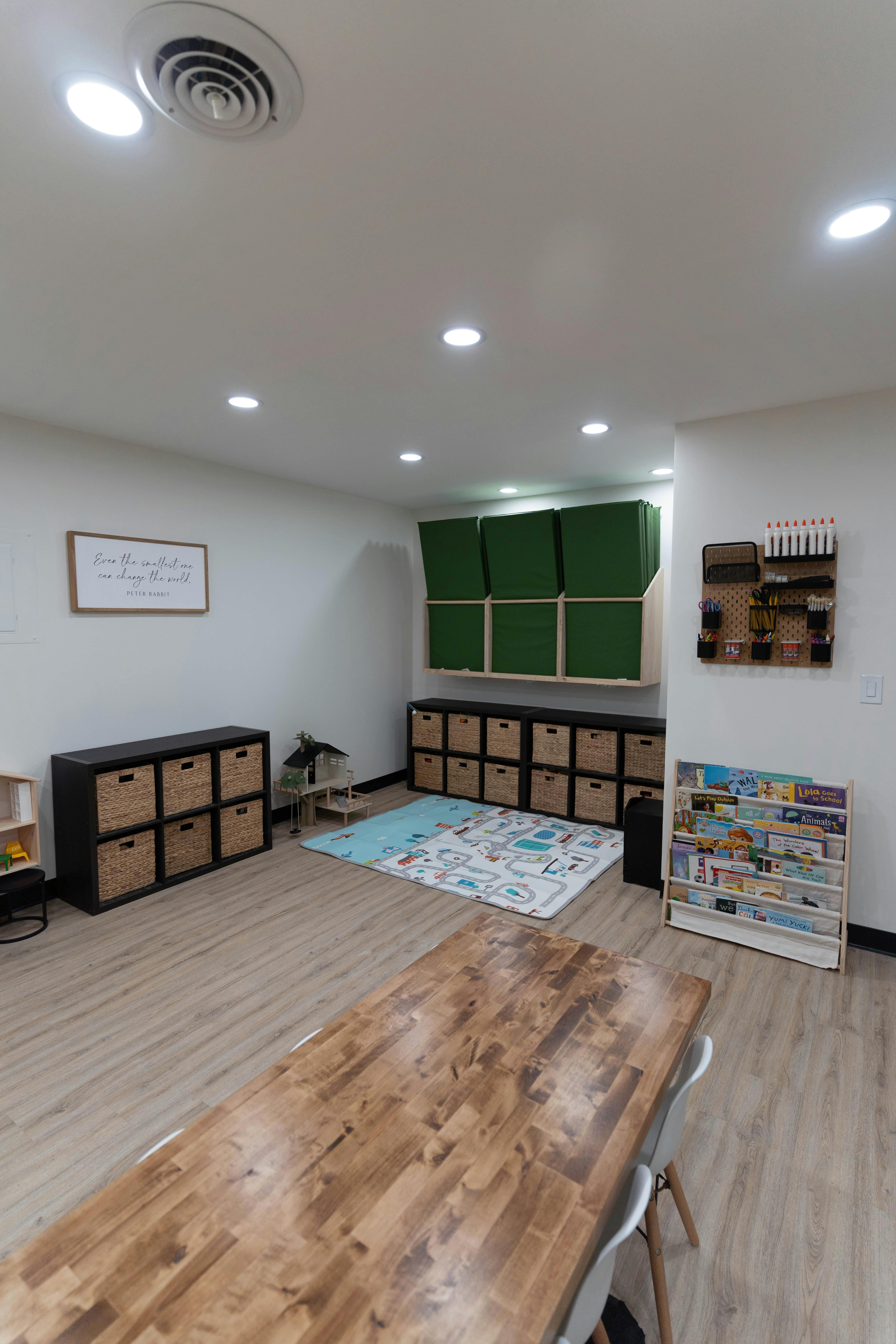 Room with wooden floor, storage units, and a rug