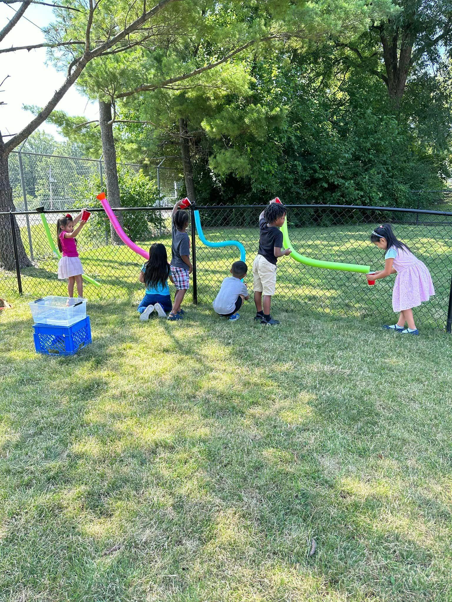 Children playing with colorful tubes outdoors