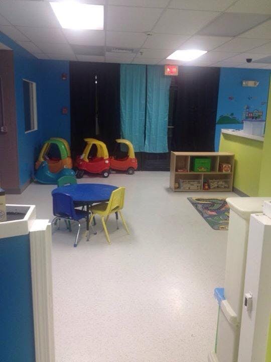 Playroom with small table and chairs, toy cars, and shelves