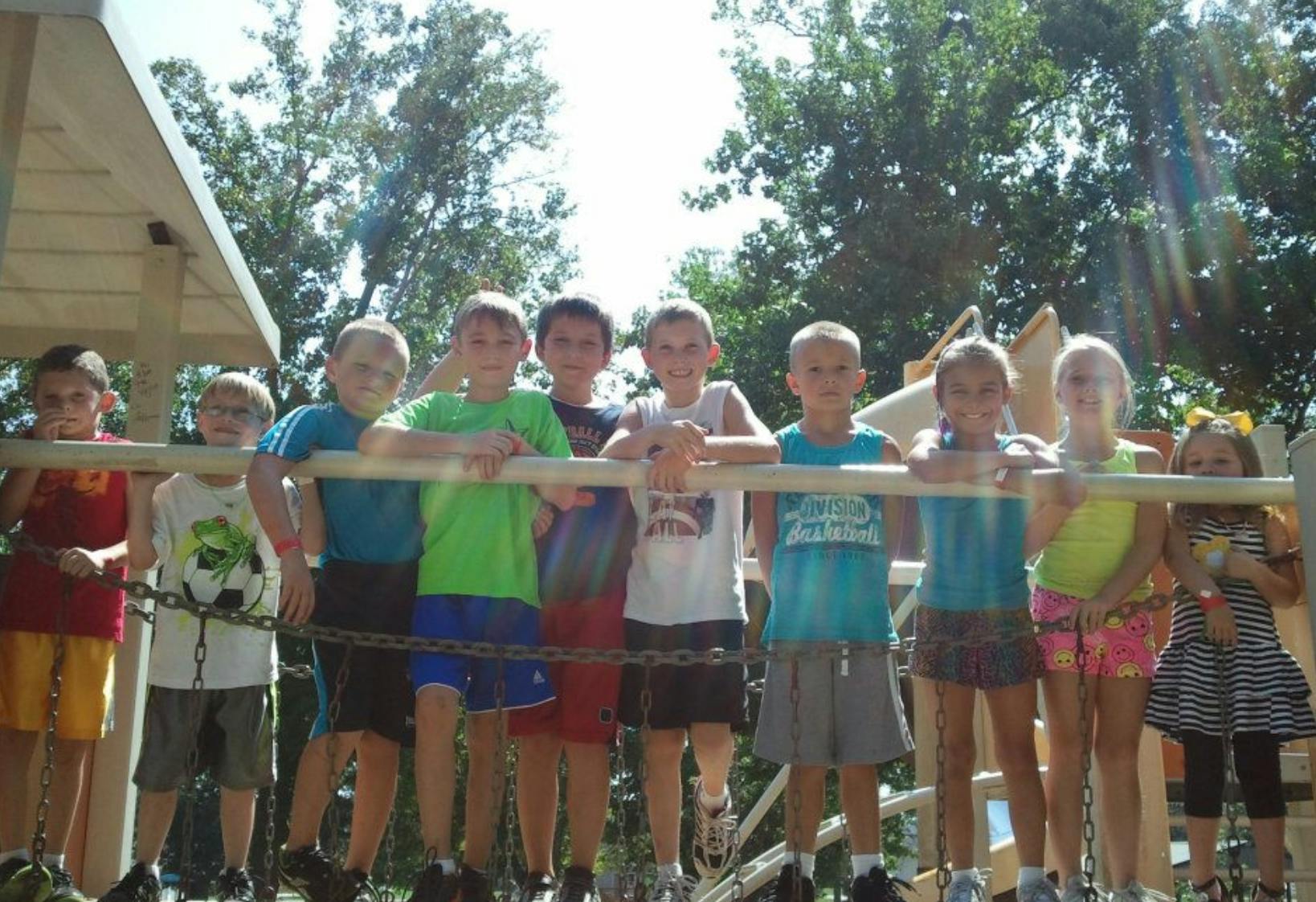 Group of children standing on a playground structure