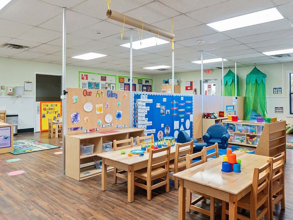 Empty colorful preschool classroom with small tables and chairs