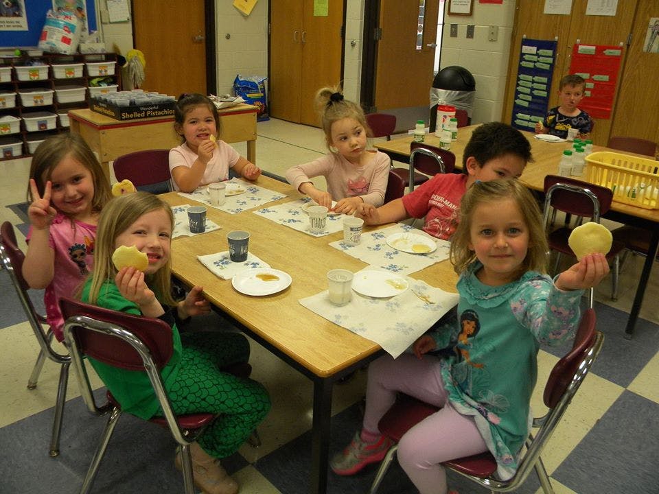 Children sitting at a table with cookies