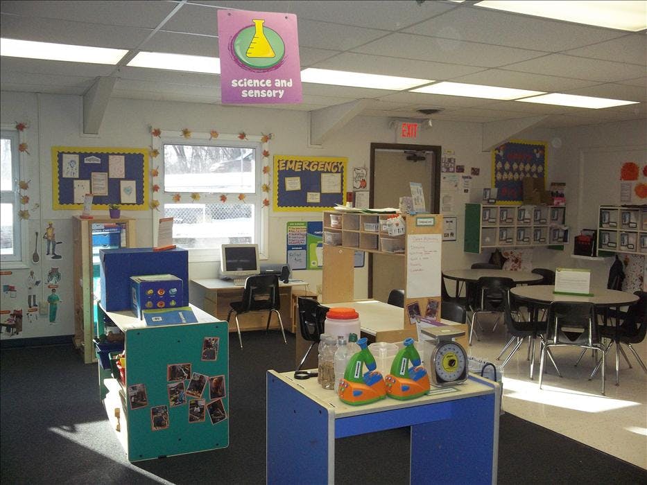 An empty classroom with science and sensory signs and various learning stations