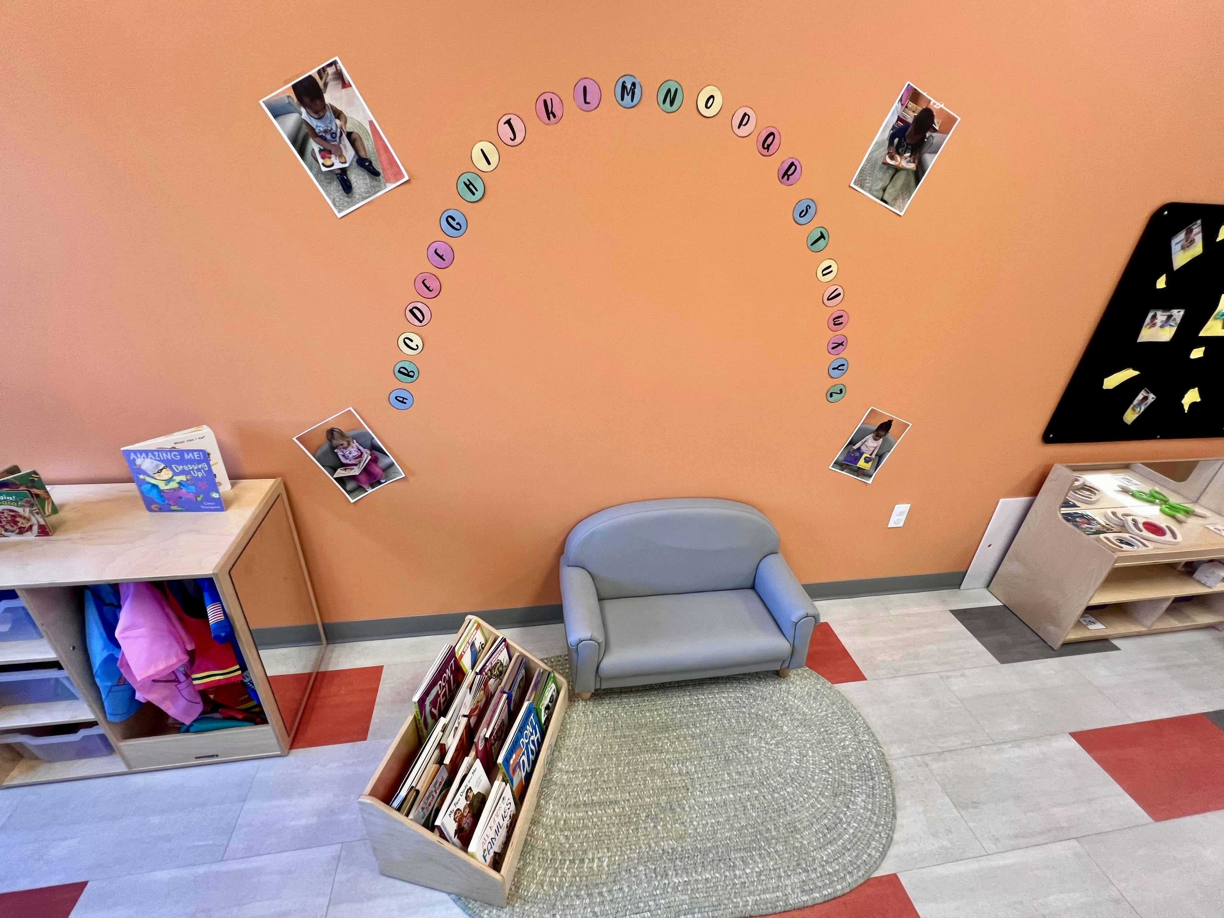 Classroom with a small gray armchair, book display, and alphabet letters on the wall