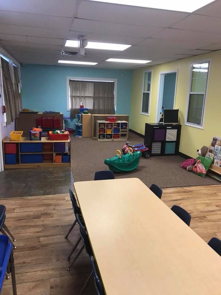 Classroom with tables, chairs, and storage units with toys