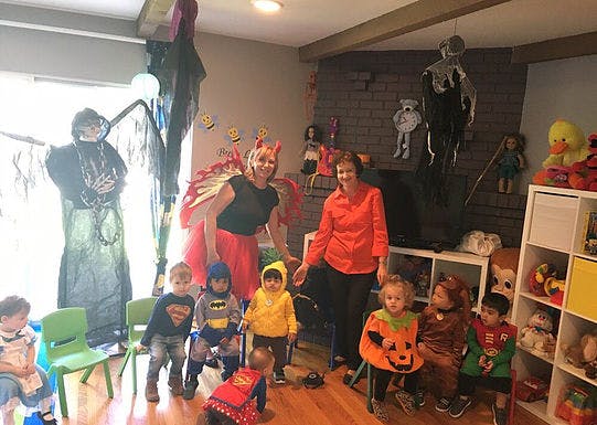 Two adults and several children in costumes in a room