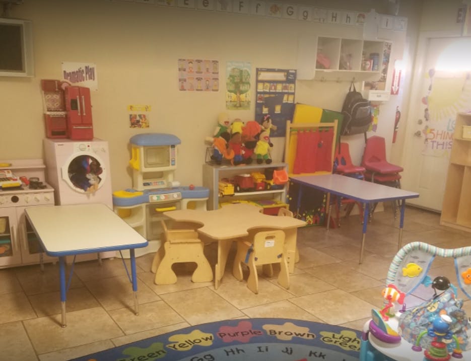 Playroom with small tables, chairs, and toy appliances