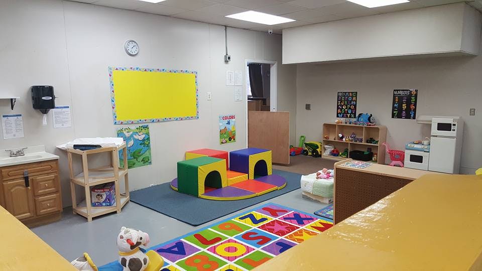 Playroom with colorful soft play equipment and alphabet rug