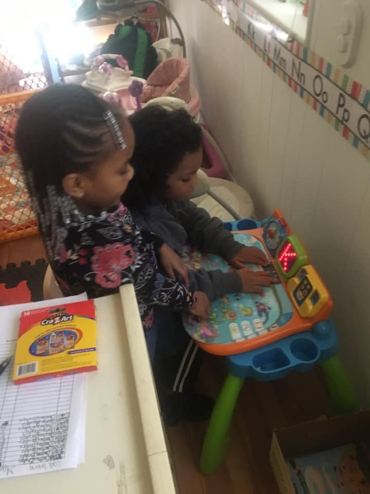 Two children playing with a colorful activity table