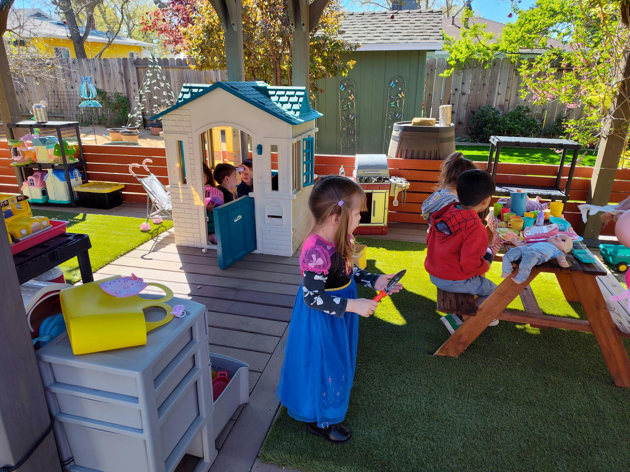 Children playing with toys in a backyard play area