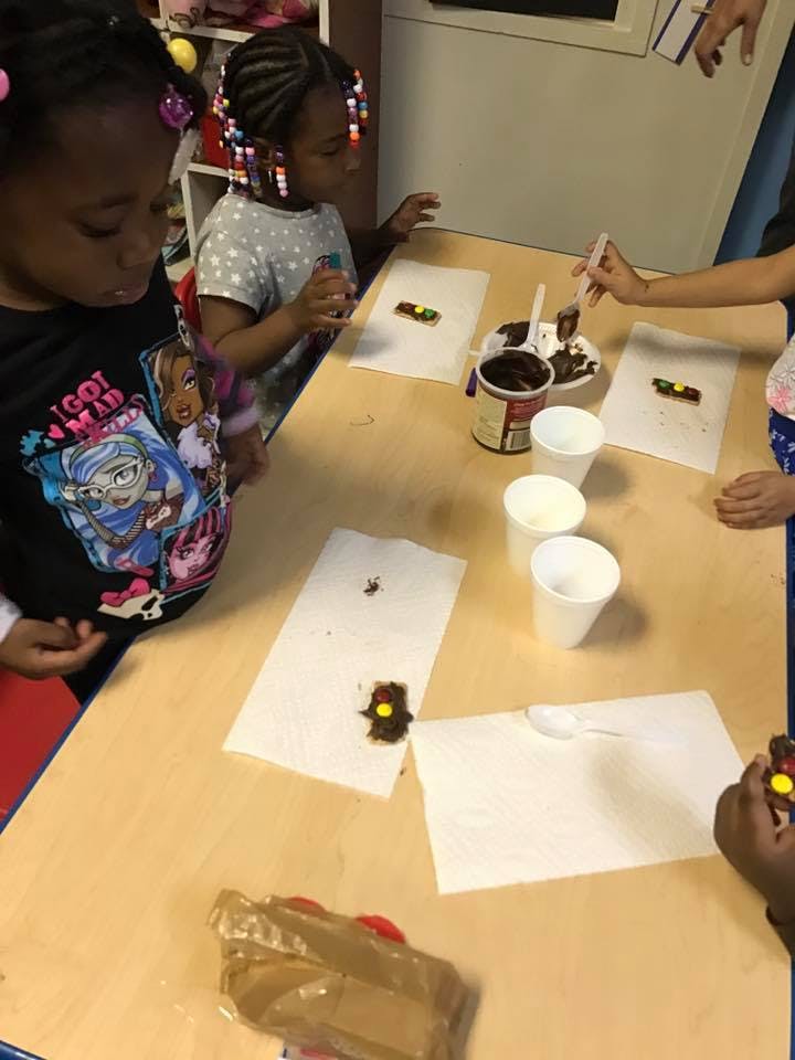 Children decorating cookies with chocolate frosting