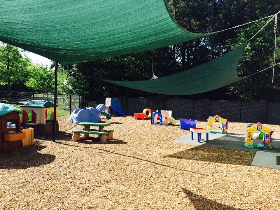 Outdoor playground with green shade sails and various play equipment
