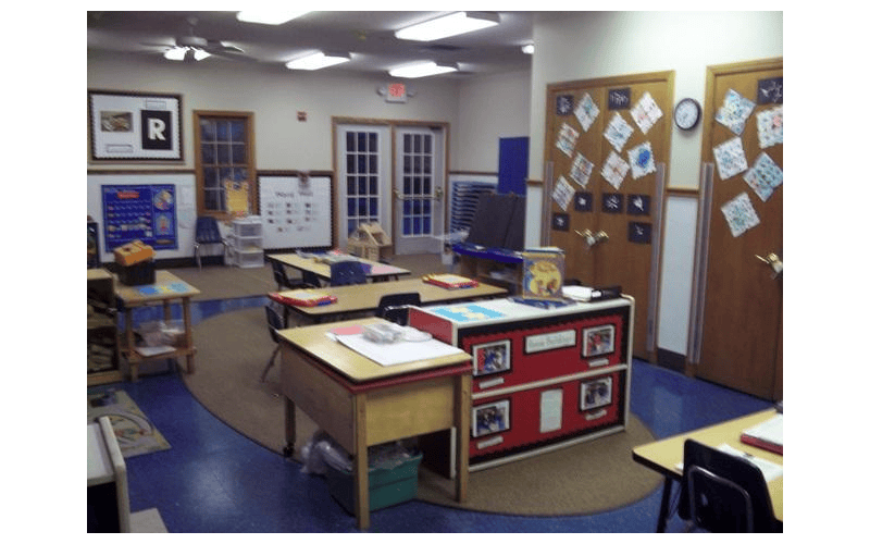 Classroom with small desks, chairs, and student artwork on the walls