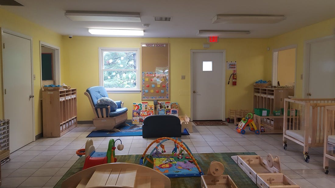 Nursery room with cribs, rocking chair, and play mats