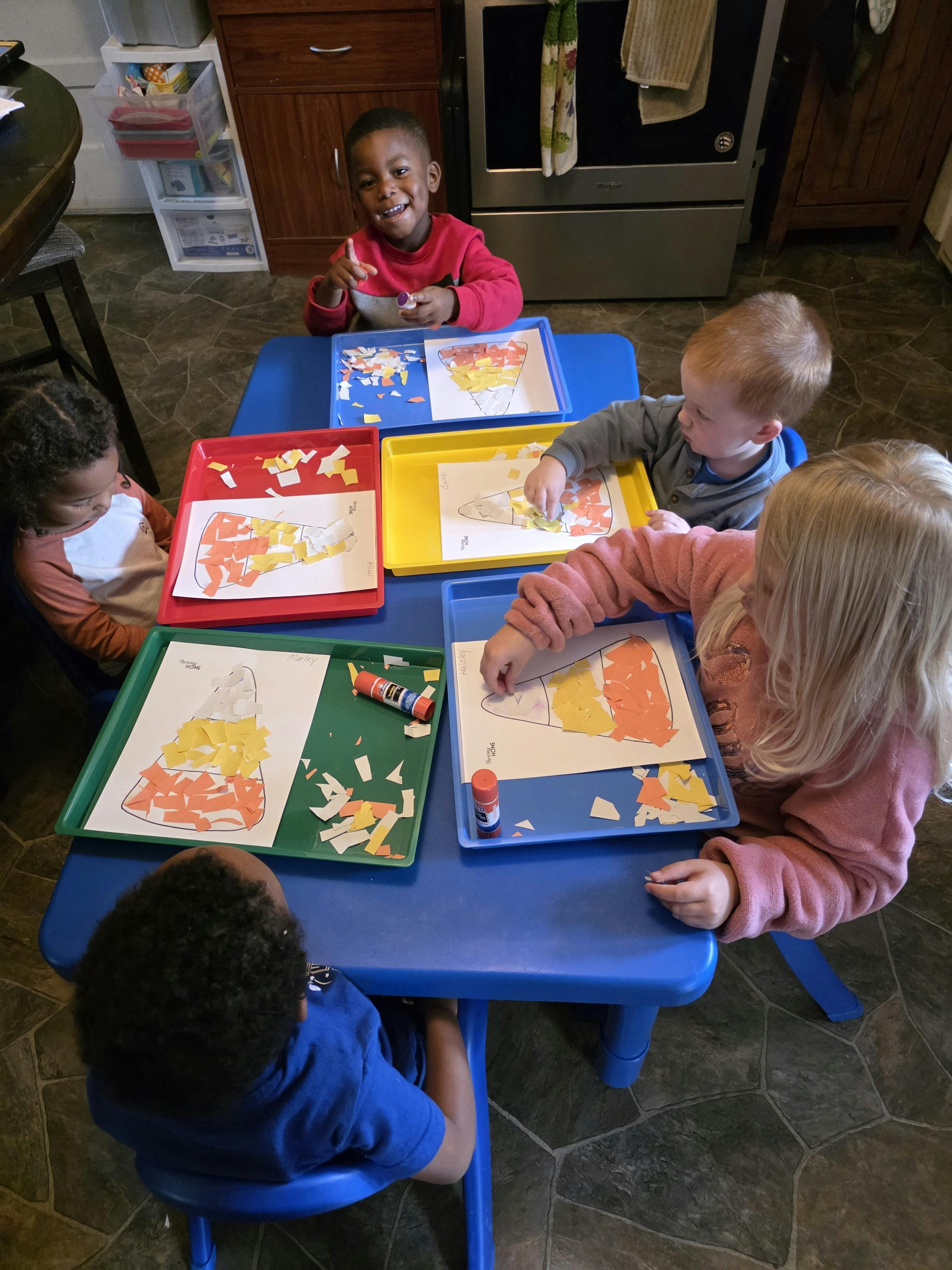 Children doing a craft activity at a blue table