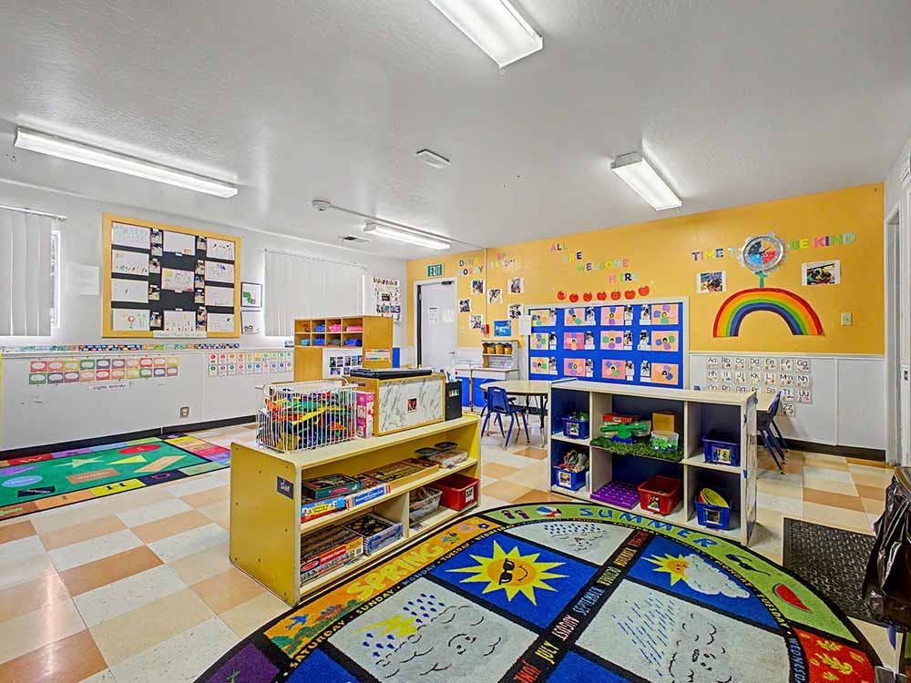 Children's classroom with brightly colored walls, rugs, and various learning materials
