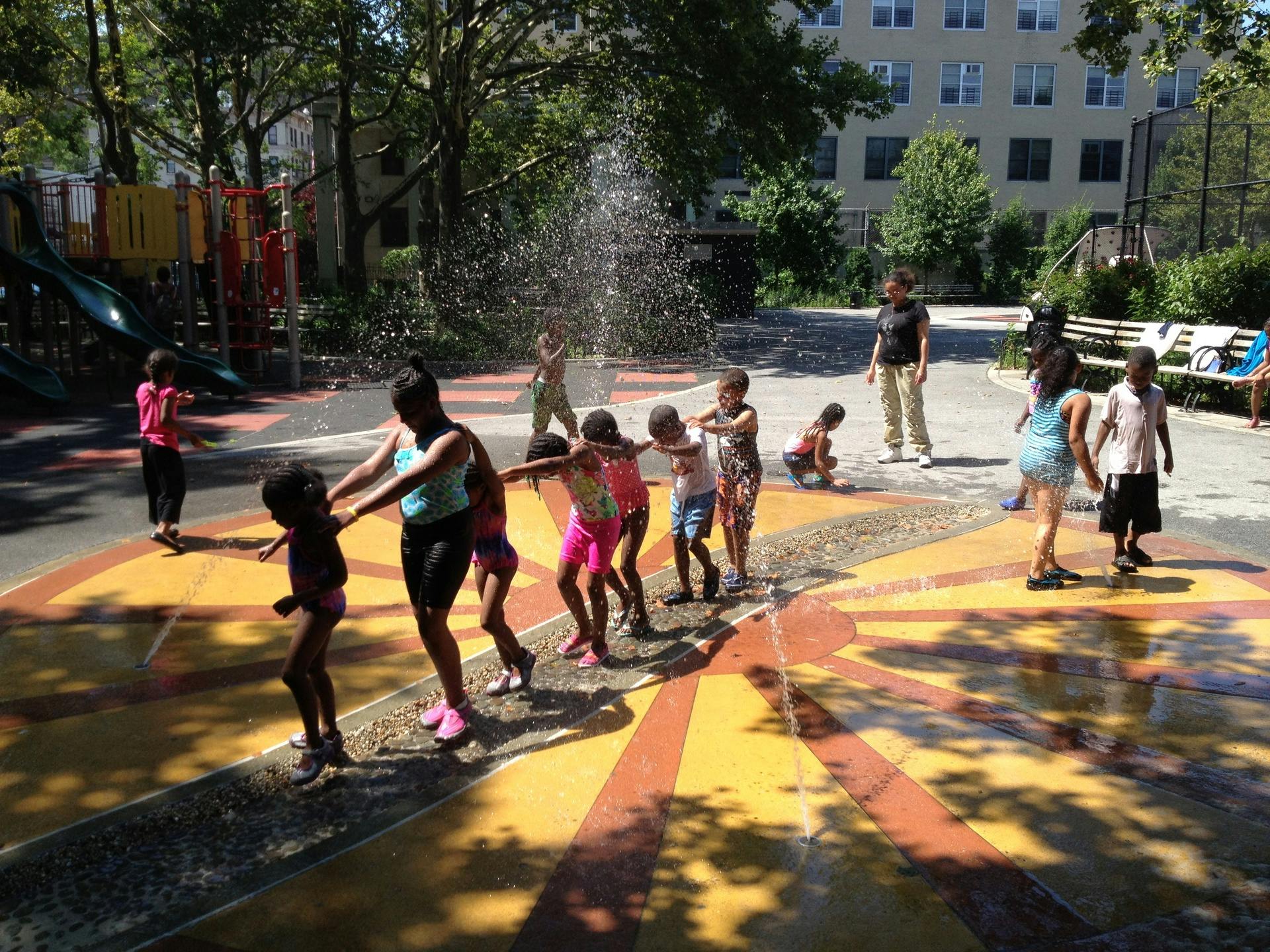 Children playing in a splash pad with water spraying